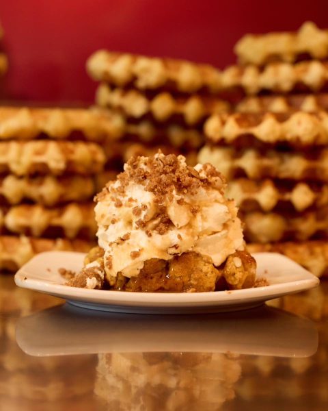 A pumpkin season waffle, shining golden, made with creamy pumpkin purée and aromatic spices.