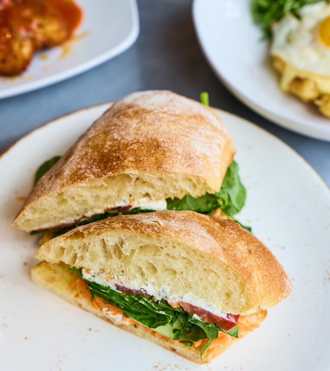 Farmer’s Fresh Ciabatta layered with cucumber, shredded carrots, arugula, herbed cheese, and lemon vinaigrette.