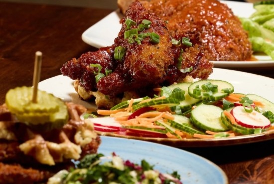 Waffle and fried chicken topped with homemade sauces on a dense Liège waffle.