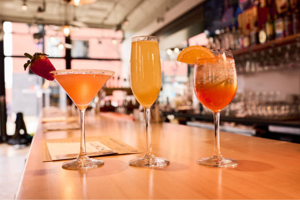 Three cocktails arranged on a bar counter at Taste of Belgium.