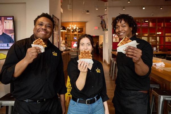 Three servers at Taste of Belgium holding waffles and posing for a picture at Findlay Market, Cincinnati.