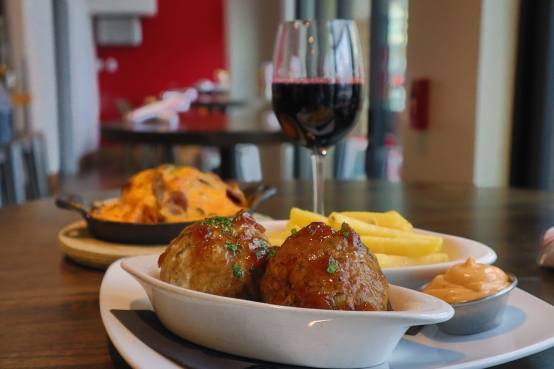 Belgian meatballs and frites with Sirop de Liège sauce served on a wooden table at Taste of Belgium in Cincinnati.
