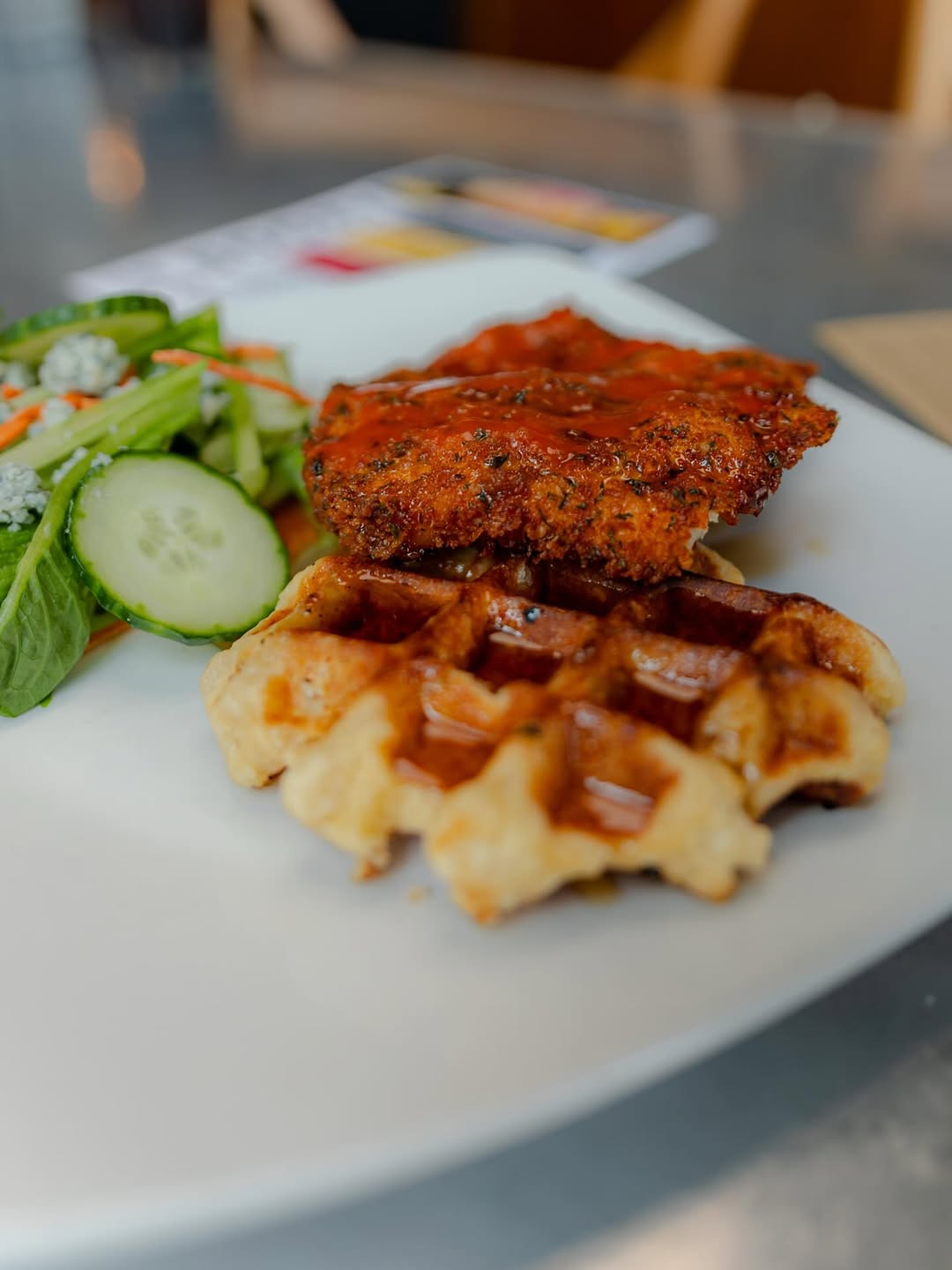 Crispy fried chicken served with Liège waffles and a side salad.