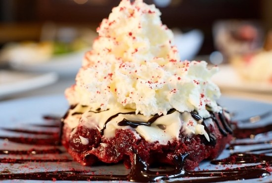 A Red Velvet Waffle from Taste of Belgium in Cincinnati, featuring a decadent topping of cream and berries.