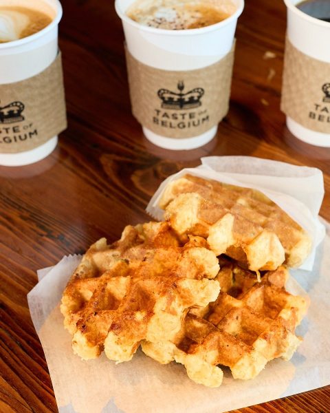 Three belgian waffles with three cups of hot coffee on the table at Taste of Belgium in Cincinnati.