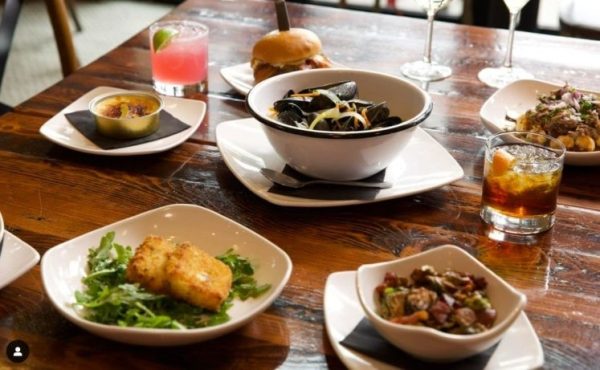 A table at Taste of Belgium restaurant in Cincinnati with various food, drinks, and beer for a Belgian-style event.
